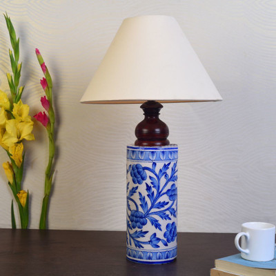 Unravel India This handpainted ceramic lamp will add an ethnic touch to your living room. Place it on the bed side table or a study table, it will equally make the place graceful. It has a cute cylindrical shape with Mugal art painting done by the artisans from Rajasthan.This work is also known as B