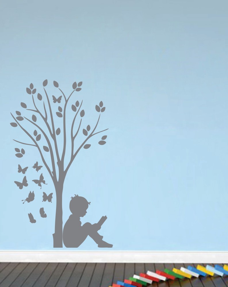 silhouette of boy reading under tree