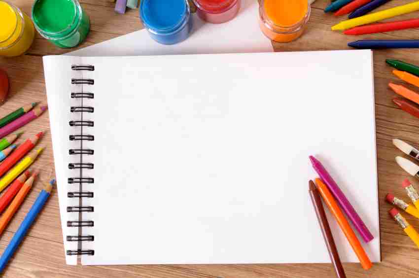 Pencils and drawing or sketch pad on wooden background. School